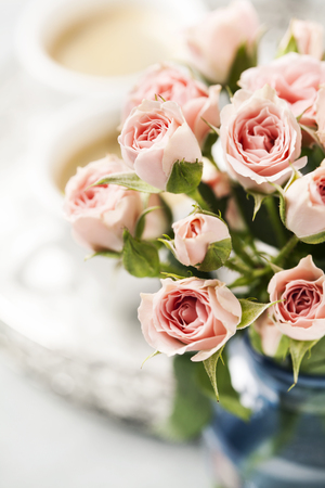 Romantic setup with coffee and roses in vaseの写真素材