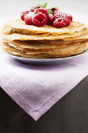 Stack of Russian-style pancakes with raspberriesの写真素材