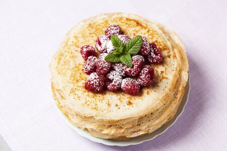 Stack of Russian-style pancakes with raspberriesの写真素材