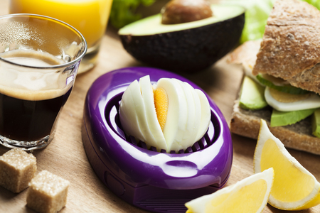 Egg slicer on table with breakfast setupの写真素材