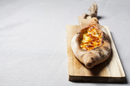 Pide - traditional Turkish bread with cheese on wooden 
boardの写真素材