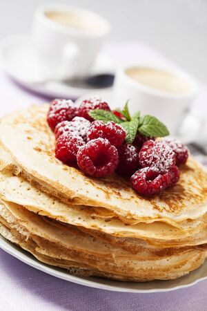 Stack of Russian-style pancakes with raspberriesの写真素材