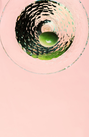 Martini cocktail with green olive on pink backgroundの写真素材