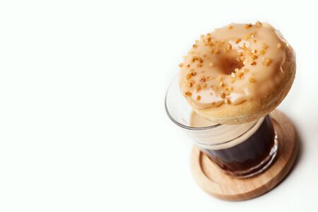 Glass of coffee and donut on whiteの写真素材