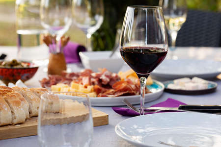 Set up table with red wine, bread and appetizersの写真素材