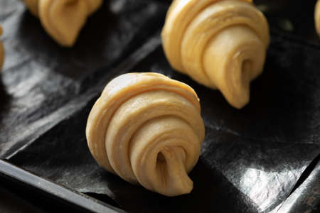 Close up of unbaked butter croissants on baking sheet