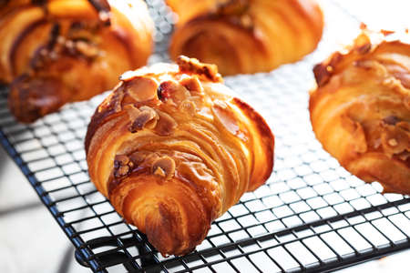 Homemade almond croissants on cooling rack