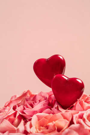 Bouquet of pink roses on pink background with two heartsの写真素材