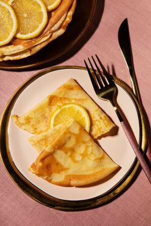 Pancake Tuesday concept, crepes and lemon on pink backgroundの写真素材