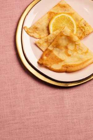Pancake Tuesday concept, crepes and lemon on pink backgroundの写真素材