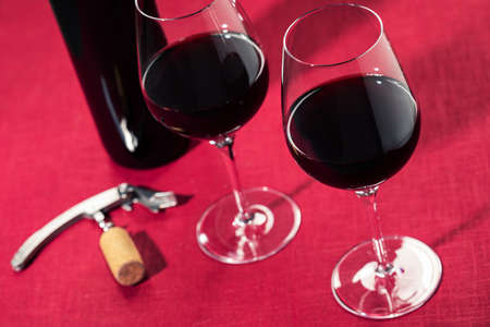 Two glasses of red wine on red linen backgroundの写真素材