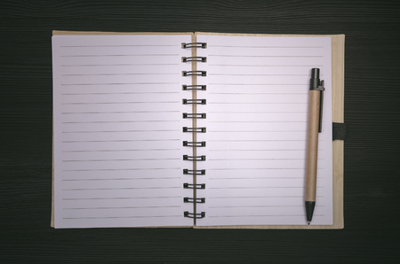 Note pad with blank paper pages with copy space isolated on black wooden board background. To do list. Tips.の写真素材