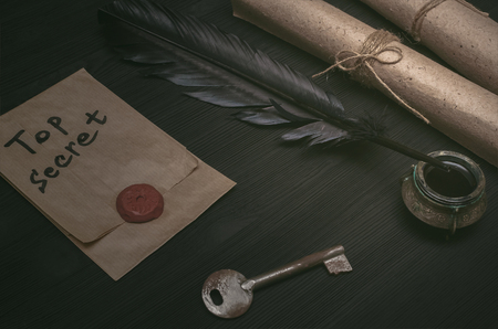 Envelope with top secret message. Key to unraveling. The clue. Detective desk table concept.の写真素材