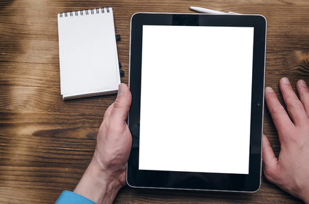 Tablet computer with blank screen with copy space in male businessman hands on office desk table background. Business project presentation mock up.の写真素材