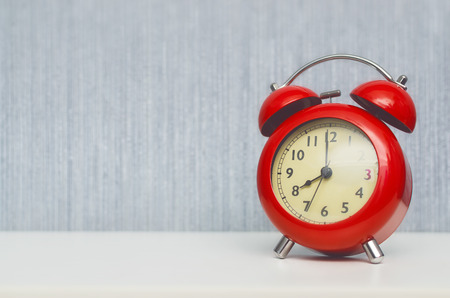 Red alarm clock on office desk table background with copy space. 8 (eight) o'clock.