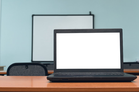 Laptop computer with blank white screen on the school desk table in classroom. Education concept background.の写真素材