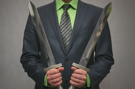 Businessman holds in hand a toy sword weapon. Life or finance insurance agent. Money deposite safety agent. Security agent concept.の写真素材