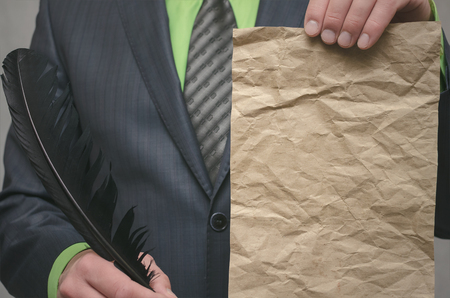 Businessman holds in hand a document message and feather pen. Signing of an agreement template. Conclusion of a business contract. Business deal concept. Special offer.
の写真素材