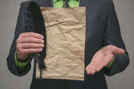 Businessman holds in hand a document message and feather pen. Signing of an agreement template. Conclusion of a business contract. Business deal concept. Special offer.
の写真素材