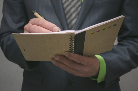 Businessman is writing text in note pad in his hands by the pen. To do list. Goals or business tricks. Business tips concept. Task Manager
concept.の写真素材