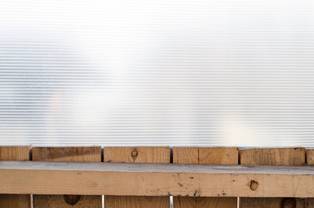 Polycarbonate and wood wall background.
