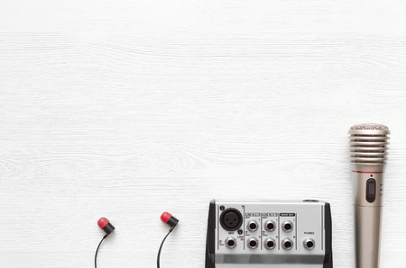 Audio recording studio desk table. Karaoke mock up. Song lyrics. Microphone, sound mixer and headphones on white wooden table background with copy space.の写真素材