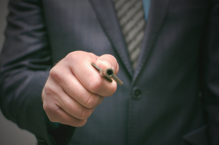 Key to success concept. Businessman holding in hands an old rusty key and opens the door, front view. Explanation of information decryption key. Access to forbidden materials.の写真素材
