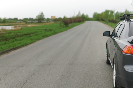 Car on the empty asphalt road in the cloudy rainy day.の写真素材
