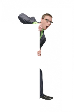 Curious business man looks out from some copy space in front of him for placard or poster message. Special offer template. Product presentation.の写真素材