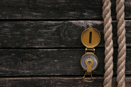 Moorings rope and compass on aged timber background.の写真素材