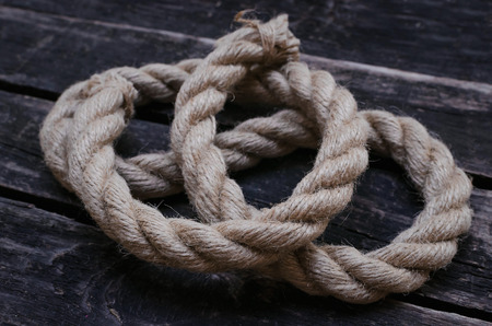 Moorings rope on aged wooden table background.