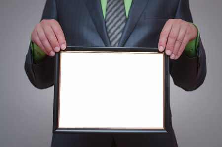 Blank diploma or certificate mock up in businessman hand. Empty photo frame border with copy space.の写真素材
