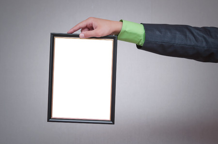 Blank diploma or certificate mock up in businessman hand. Empty photo frame border with copy space.