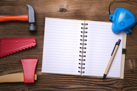 Blank page notepad and different building toy tools. Construction background with copy space. Fix...