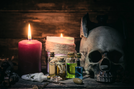 Magic potion and human skull on magic table background. Witchcraft concept.の写真素材