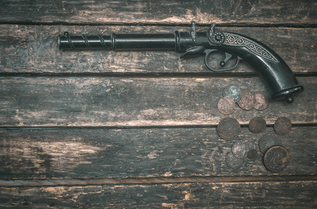 Musket gun and money on wooden table background. Duel.の写真素材