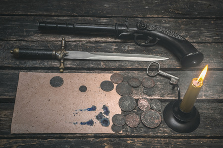 Blank page document, weapon, money and burning candle on the wooden desk table. Compromising evidence.の写真素材