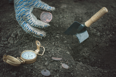 Aged 5 kopeks coin of Russian empire in the hand of coin finder. Treasure hunting concept. In search of a lost treasure.の写真素材