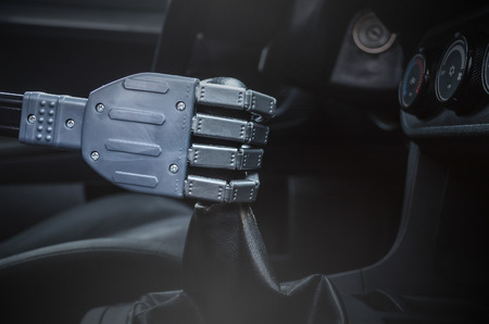Robot hand on car gearstick. Robot pilot is driving a car. Automatic driver concept.の写真素材