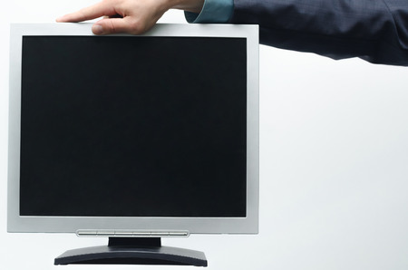 TV computer monitor with blank screen in the businessman hand isolated on white background.の写真素材