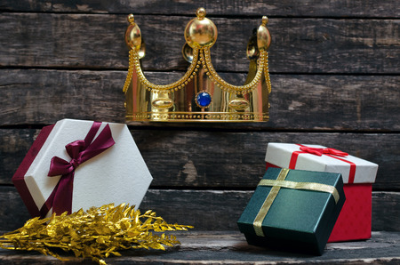Present box on the table with golden king crown above. Royal gift concept.の写真素材