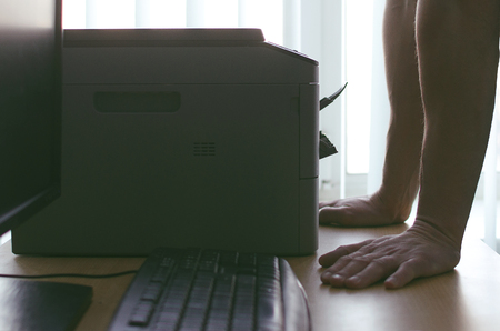 Businessman working with printer or scanner. Office paperwork concept.の写真素材