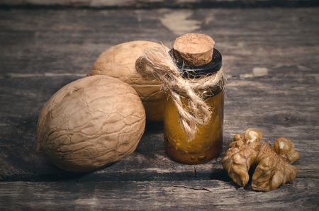 Walnut oil in the bottle on the wooden table background.の写真素材