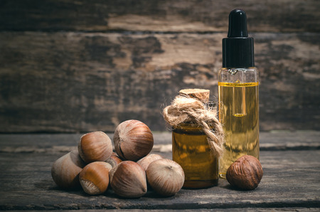 Hazelnut nut oil in the bottle on the wooden table background.