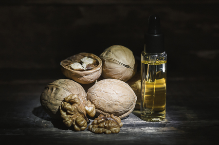 Walnut oil in the bottle on the wooden table background.の写真素材