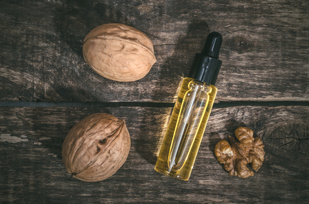 Walnut oil in the bottle on the wooden table background.の写真素材