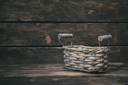 Empty wicker basket on a wooden table background with copy space.の写真素材