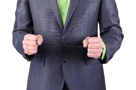 Handcuffs on a businessman hands isolated on a white background.の写真素材