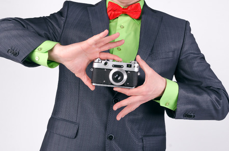 Vintage film photo camera in a photographer hands isolated on a gray background.の写真素材