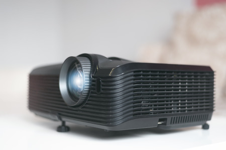 Black projector on a table. Home movie theatre concept background.の写真素材